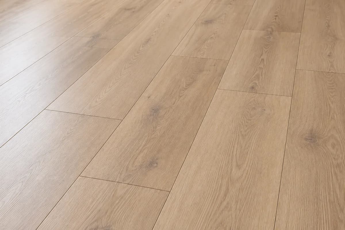 Close-up of pale oak-look vinyl planks with subtle grain and staggered joints.