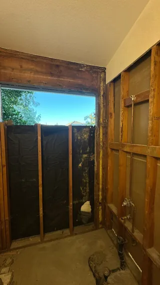 Exposed framing around a bathroom window with the wall finishes removed.